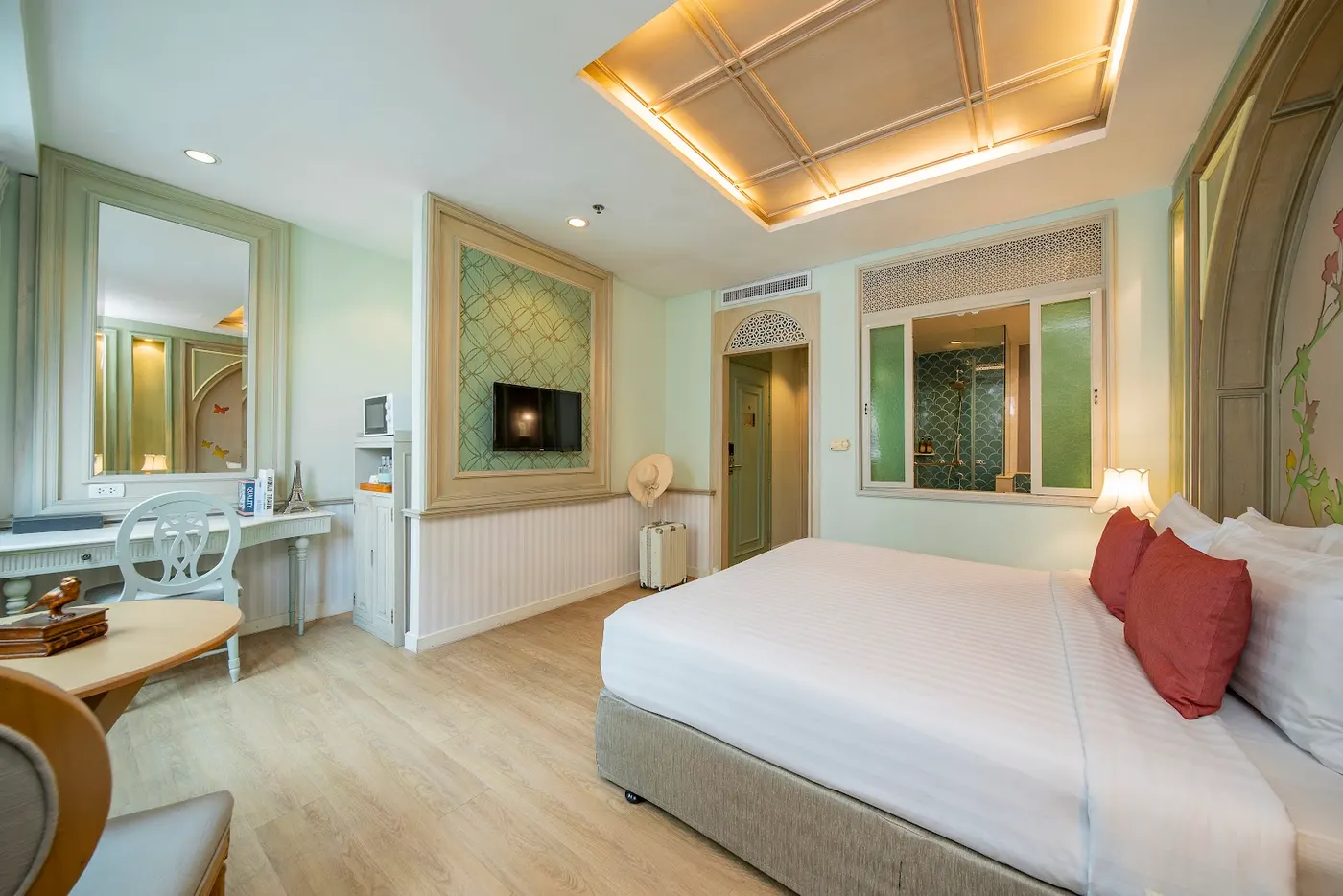 Guest room with a king bed and a dressing table at La Petite Salil Sukhumvit 11
