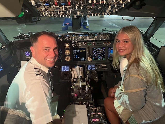 Michael Gonzales in his pilot uniform with his daughter Emma in an airliner cockpit