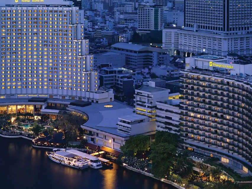 Shangri-La Bangkok towers on the Chao Phraya River at dusk via Expedia