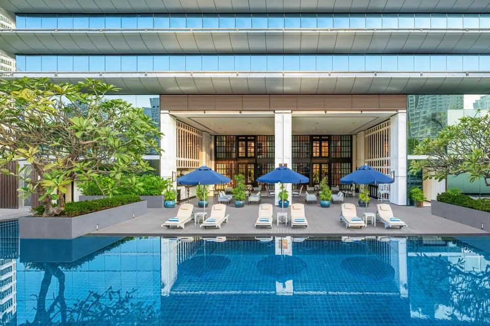 The Athenee Hotel outdoor pool and sun loungers below the hotel via Expedia